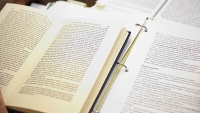 Textbook lays open on desk.